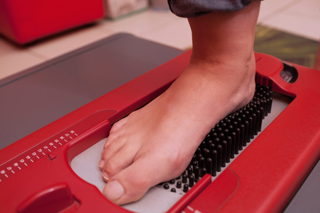 Custom Orthotics Guide for Edgewater Residents.. Close-up shot of foot being scanned on orthopedic device which creating a digital footstep model, helping to make perfect-fitting footwear in Edgewater, Florida