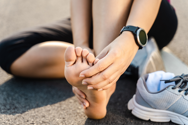 Running injury leg accident- runner hurting holding painful sprained ankle in pain.